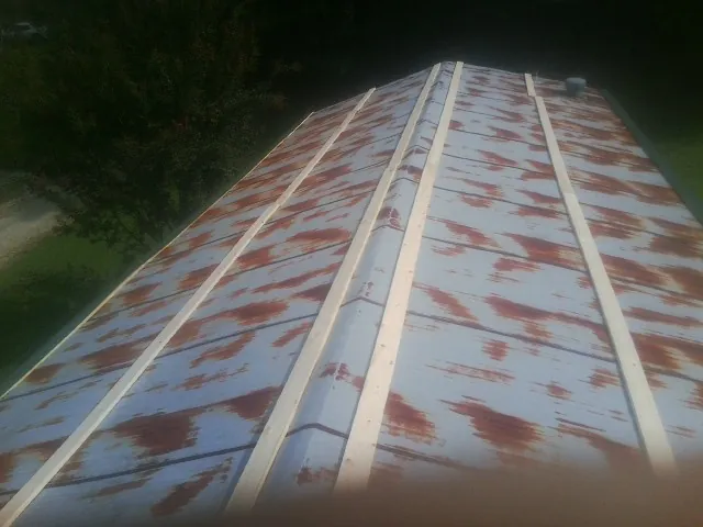 Rusted metal roof panels with new wood purlins before replacement — Storm Damage Roof Repair in Stokesdale by Roofing Brothers