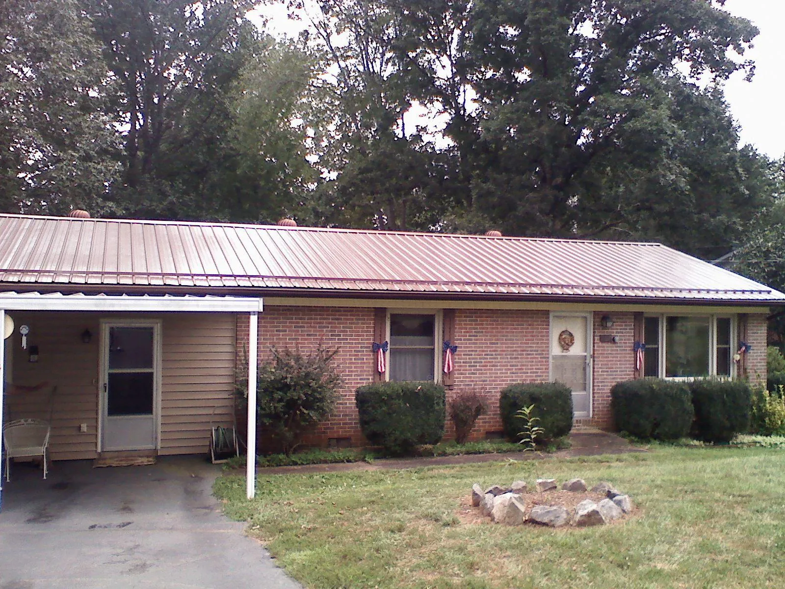 Bronze metal roof and carport on a brick ranch home — Roof Repair work by our crew in Stokesdale